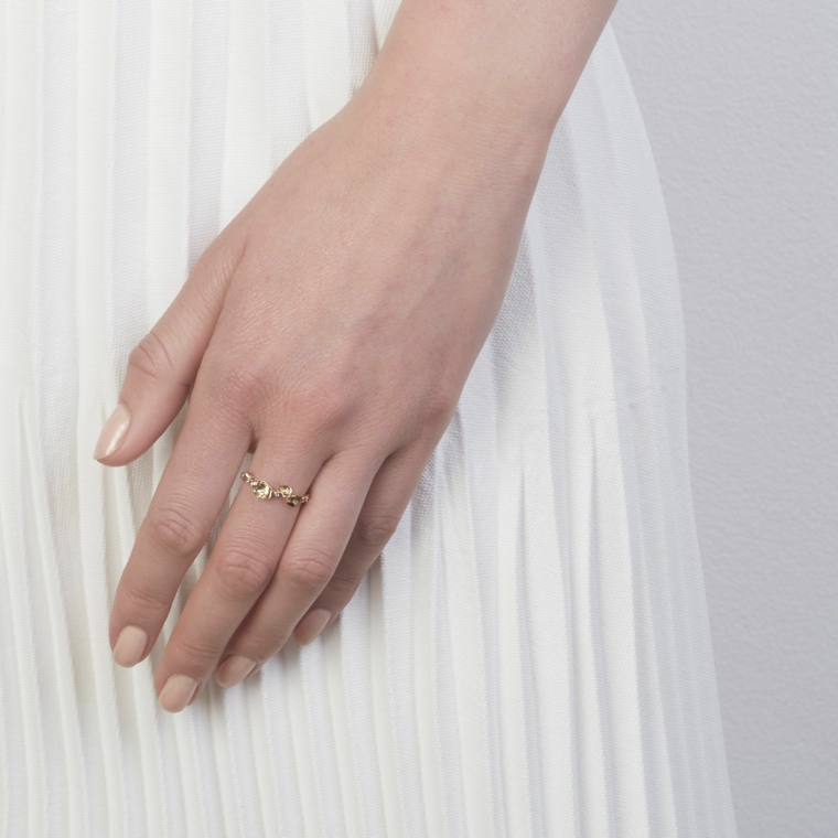 Unghie gel semplici, smalto di colore beige, manicure forma arrotondata, anello sul dito medio