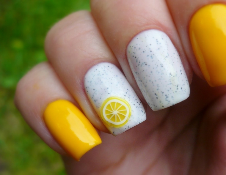 Idea per una manicure estiva di colore giallo, decorazione con un disegno di limone su una base bianca effetto marmo 